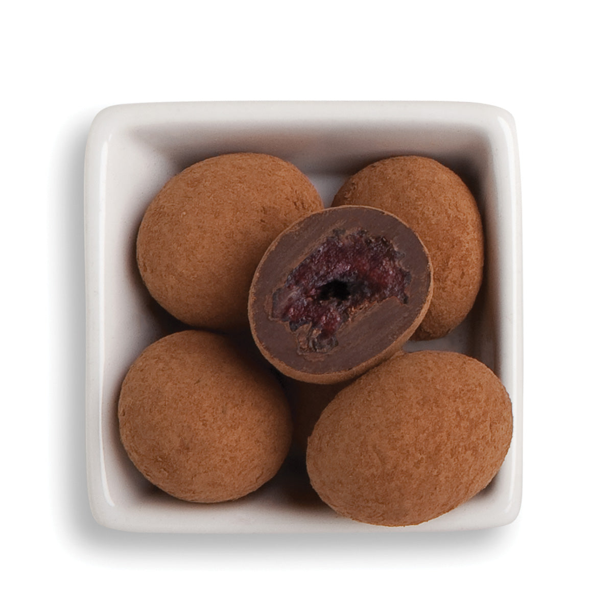 Whole and cut organic chocolate tart cherries in white bowl
