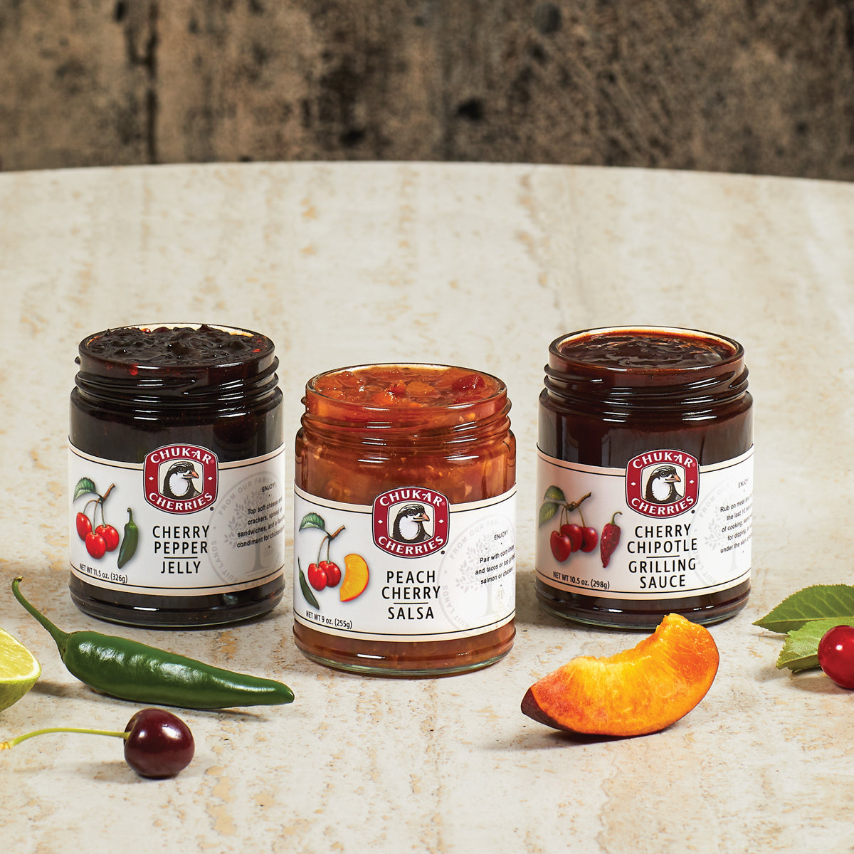 Open jars of cherry pepper jelly, peach cherry salsa, and cherry chipotle grilling sauce