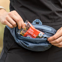 Package of no sugar added triple cherry nut being pulled out of a fanny pack.