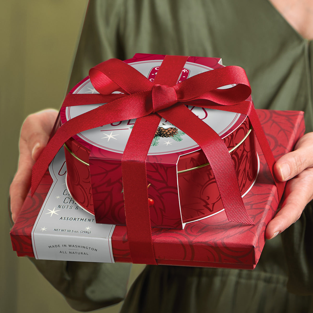 Closed assortment and tin in a tower tied with a red bow