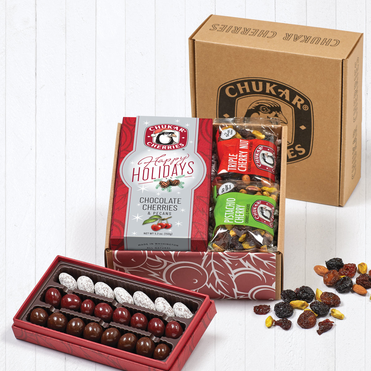 Open box of holiday classic gift box showing packaging and contents for happy holidays cherries and pecans classic assortment, pistachio cherry, and triple cherry nut