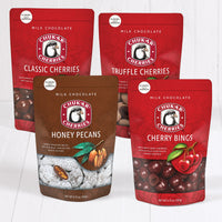 Closed bags of classic milk cherries, truffle cherries, honey pecans, and cherry bings,  in milk chocolate bundle