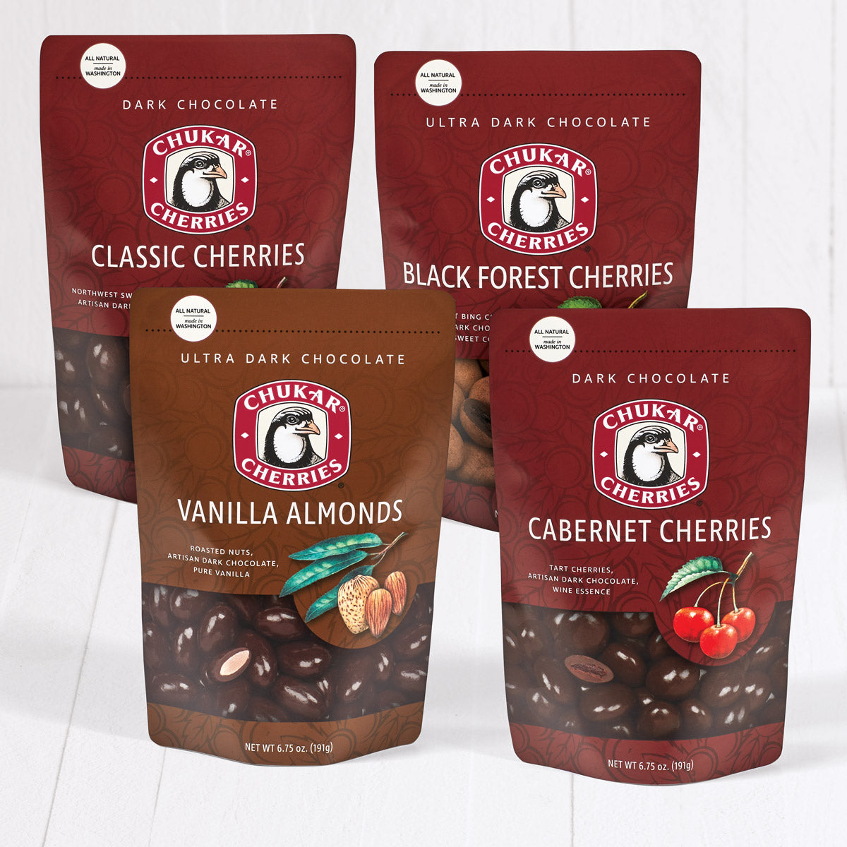 Classic dark chocolate cherries, ultra dark chocolate black forest cherries, ultra dark chocolate vanilla almonds, and dark chocolate cabernet cherries shown in closed bags in dark chocolate bundle