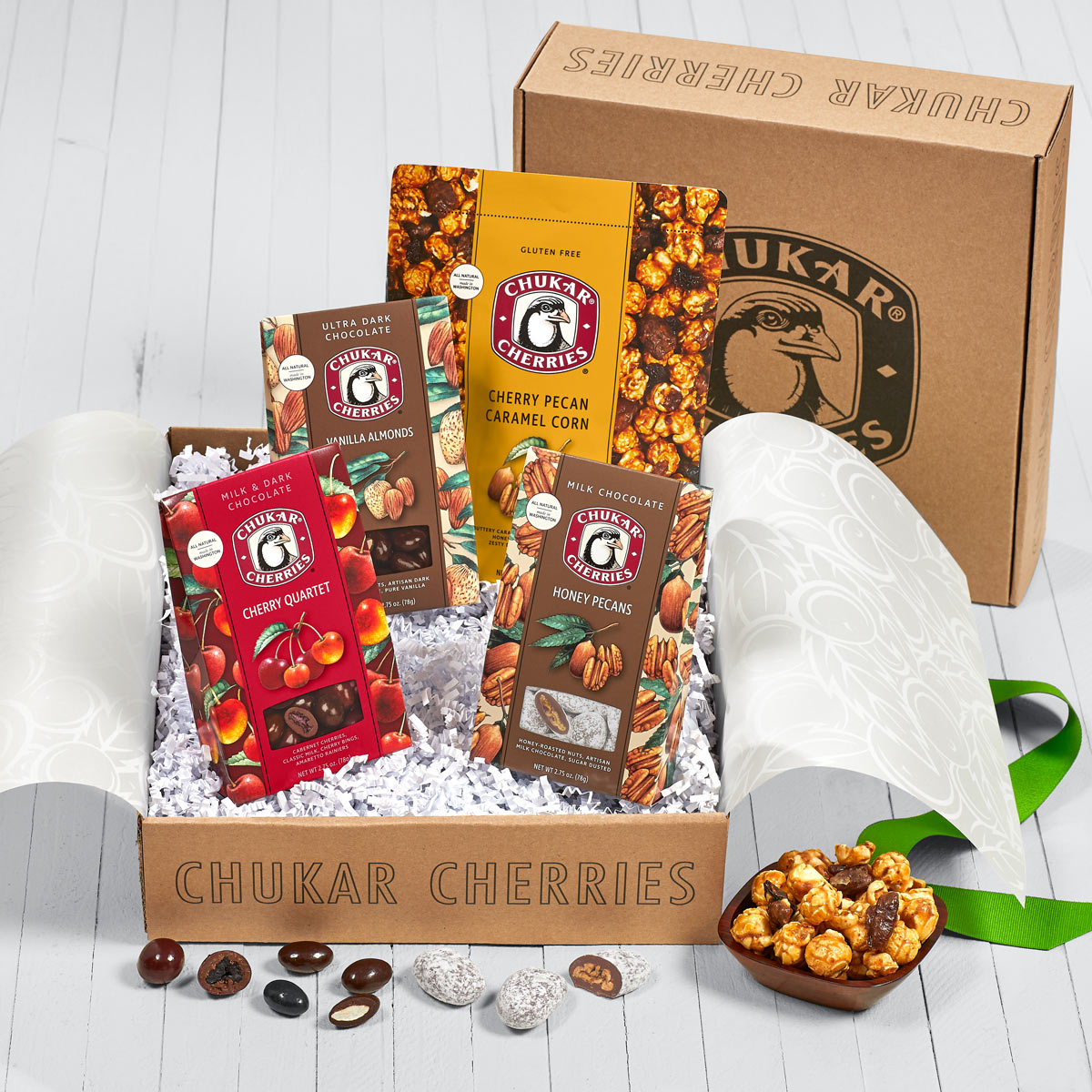 Open box showing included vanilla almonds, honey pecans, cherry pecan caramel corn, and chocolate cherry quartet