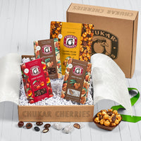 Open box showing included vanilla almonds, honey pecans, cherry pecan caramel corn, and chocolate cherry quartet