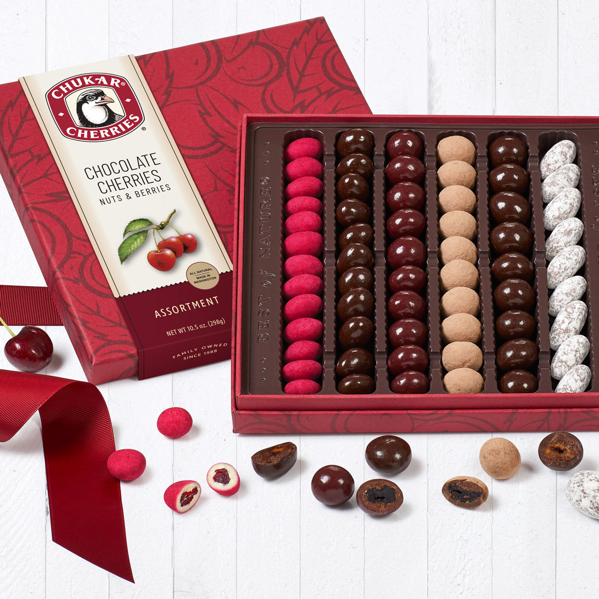 Open original assortment showing six rows filled with chocolate covered cherries, nuts, and berries.