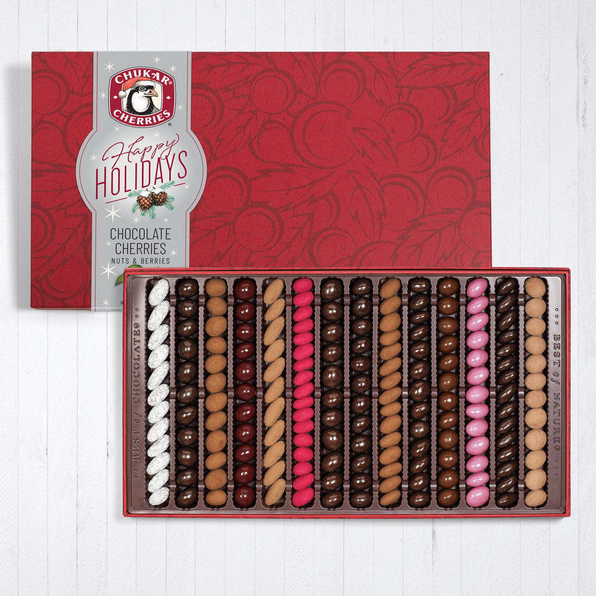 Open fourteen row happy holidays sumptuous assortment showing rows filled with chocolate covered cherries, nuts, and berries