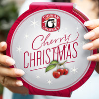 Cherry christmas tin being held with close up view of top