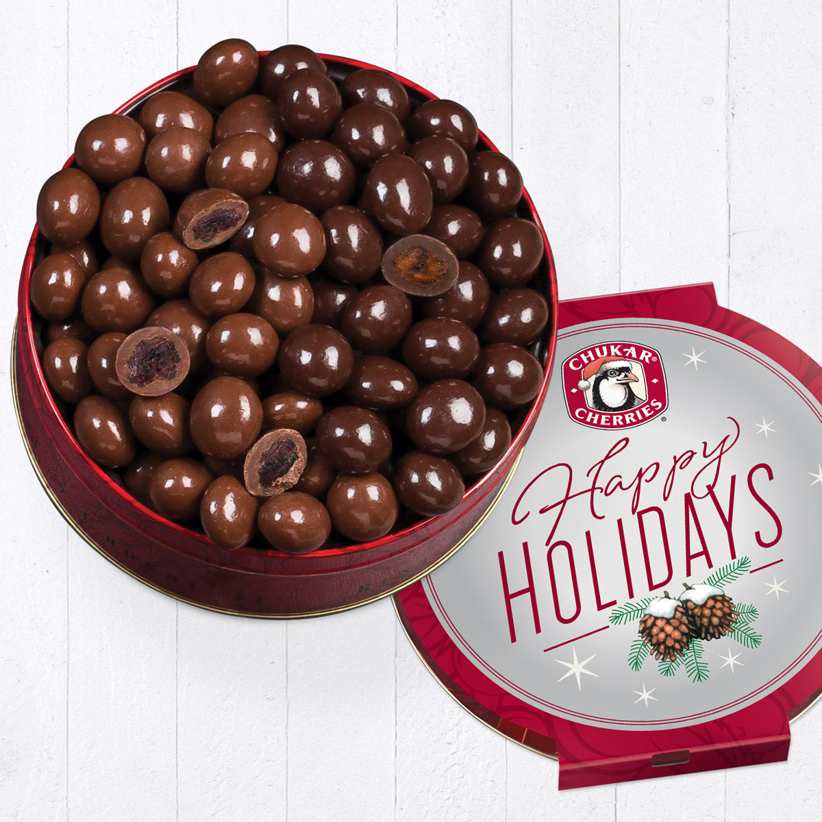 Open happy holidays milk and dark chocolate classic gift tin with four cut pieces on top