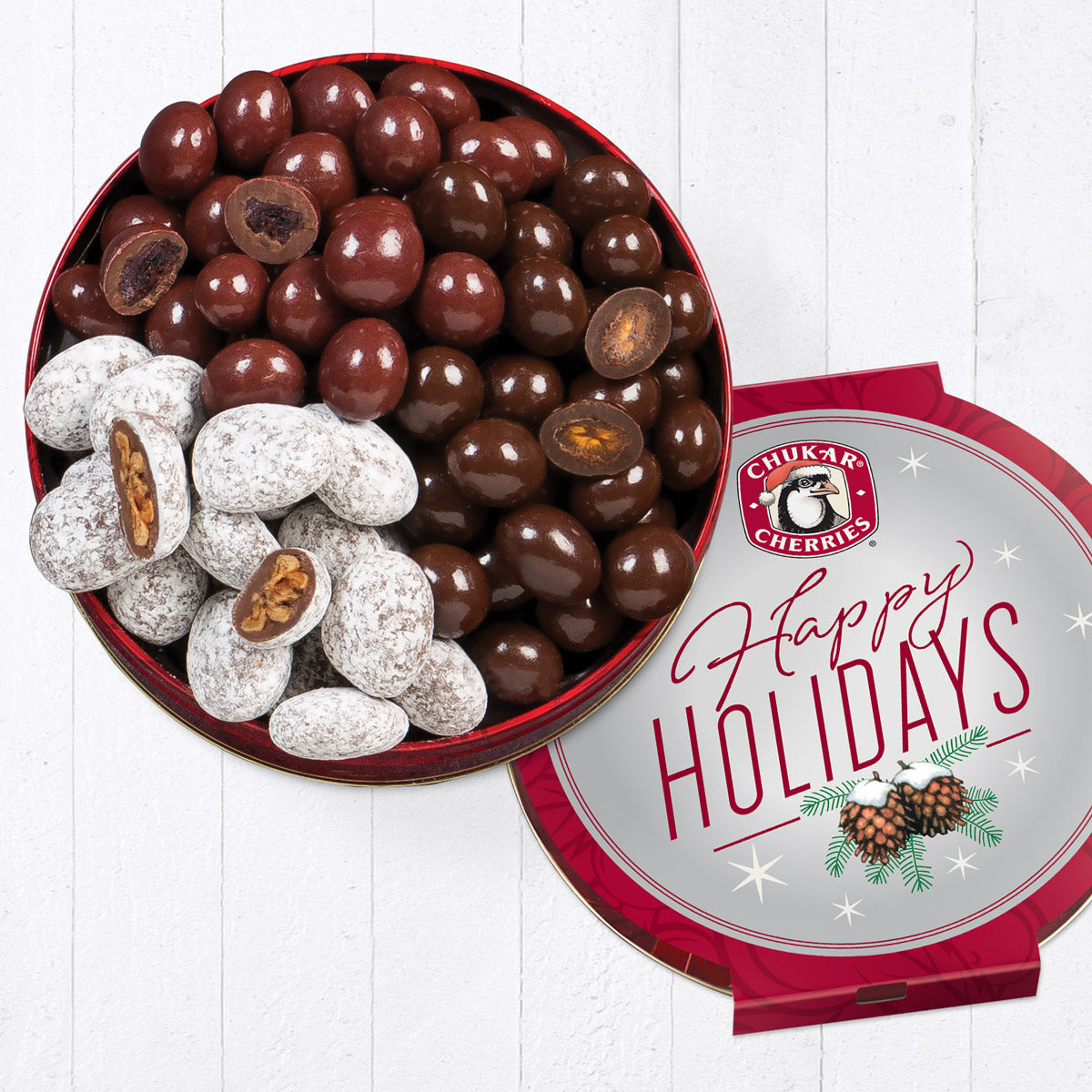Open happy holidays cherry and pecan tin showing whole and cut milk chocolate cherry bings, classic dark chocolate cherries, and milk chocolate honey pecans