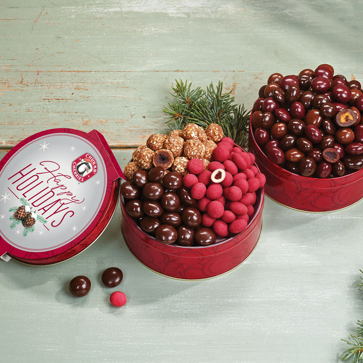 Collection of two holiday chocolate cherry, nut, and berry tins
