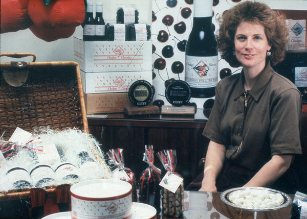 Pam behind a counter with Chukar cherries and preserves.