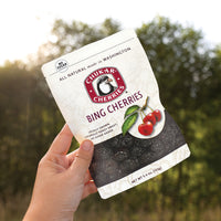 Hand holding bing cherries bag