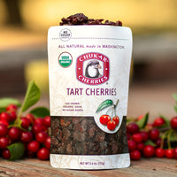 Open bag of organic tart cherries with blurred fresh cherries in the background