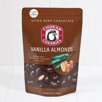Whole and cut ultra dark chocolate vanilla almonds shown in closed resealable bag