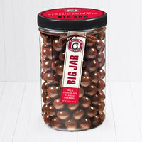 Closed big jar of milk chocolate cherries