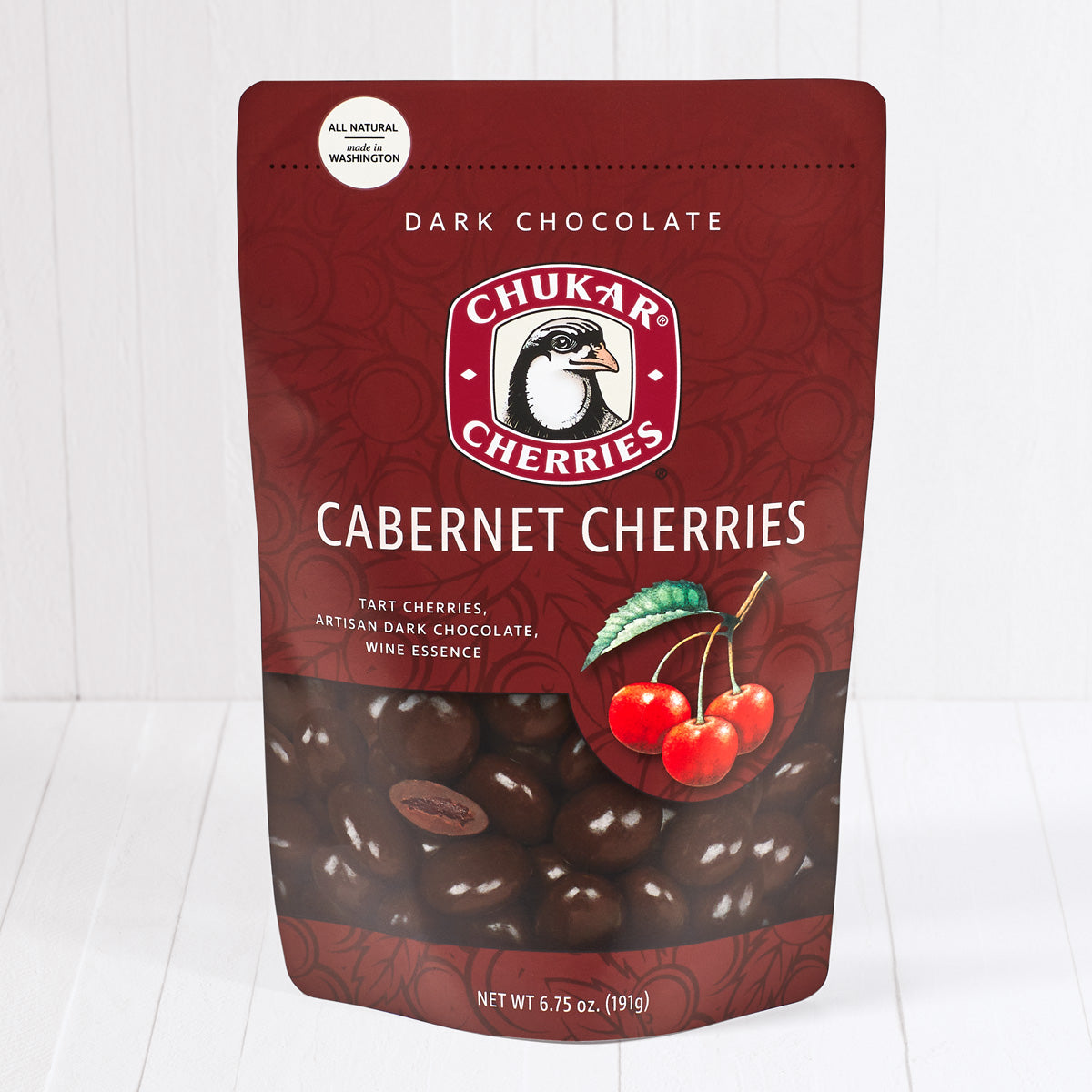 Whole and cut dark chocolate cabernet cherries shown in closed resealable bag