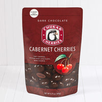 Whole and cut dark chocolate cabernet cherries shown in closed resealable bag