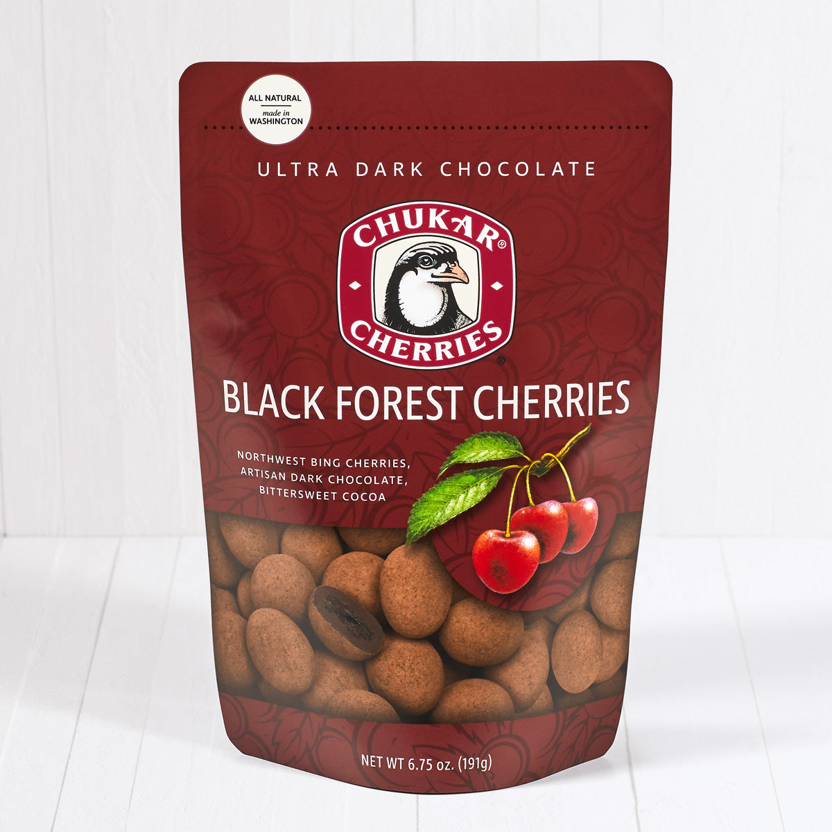 Whole and cut ultra dark chocolate black forest cherries shown in closed resealable bag
