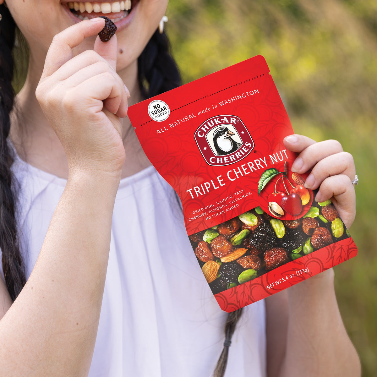 Woman holding triple cherry nut bag and dried bing cherry