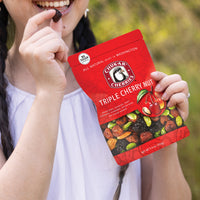 Woman holding triple cherry nut bag and dried bing cherry