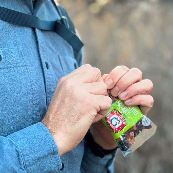 Man opening bag of pistachio cherry outdoors