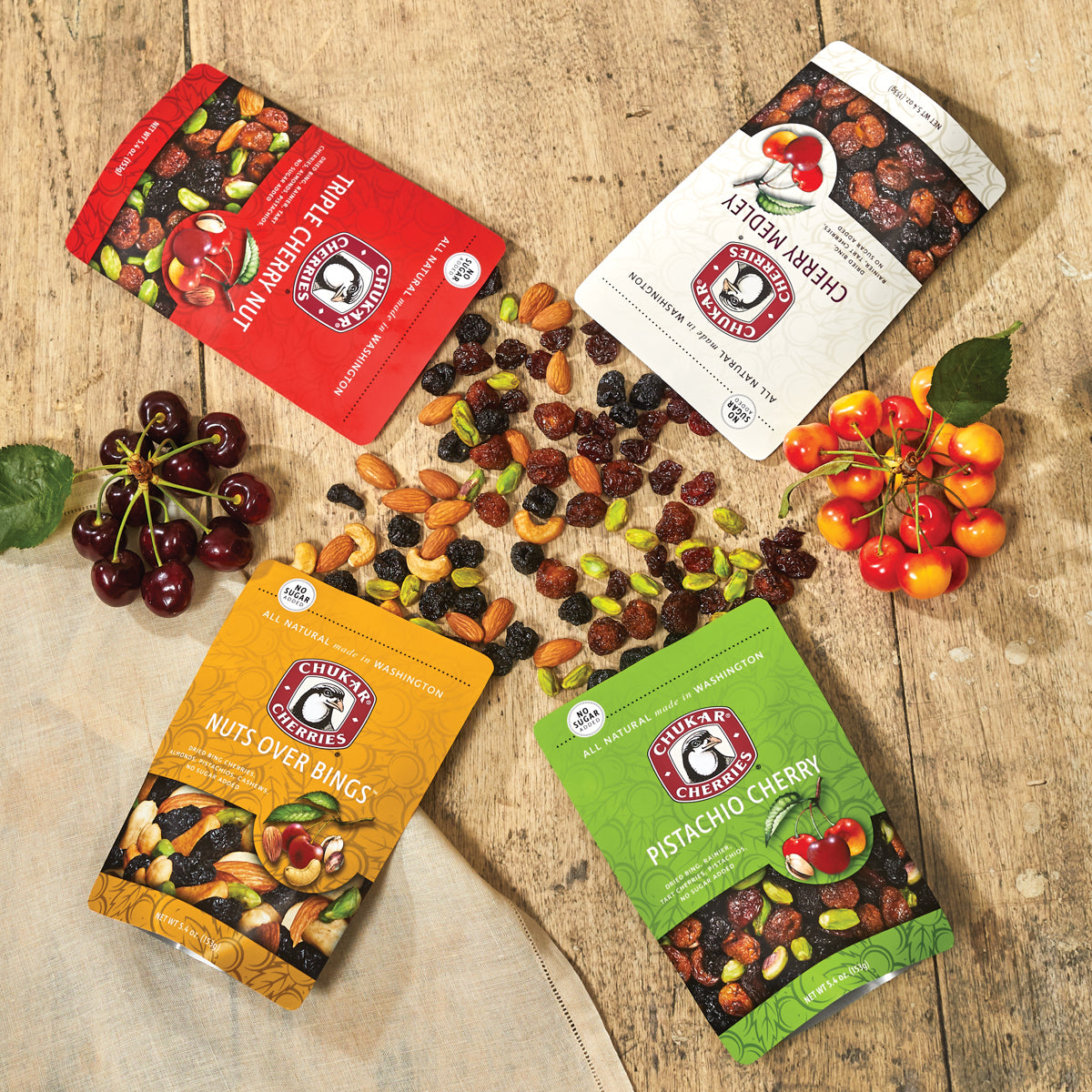 Bags and spills of pistachio cherry, nuts over bings, triple cherry nut, and cherry medley dried cherry and nut mixes