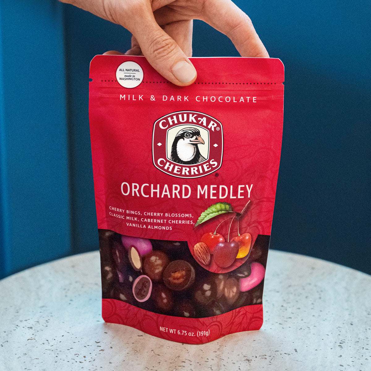 Hand holding orchard medley bag on table