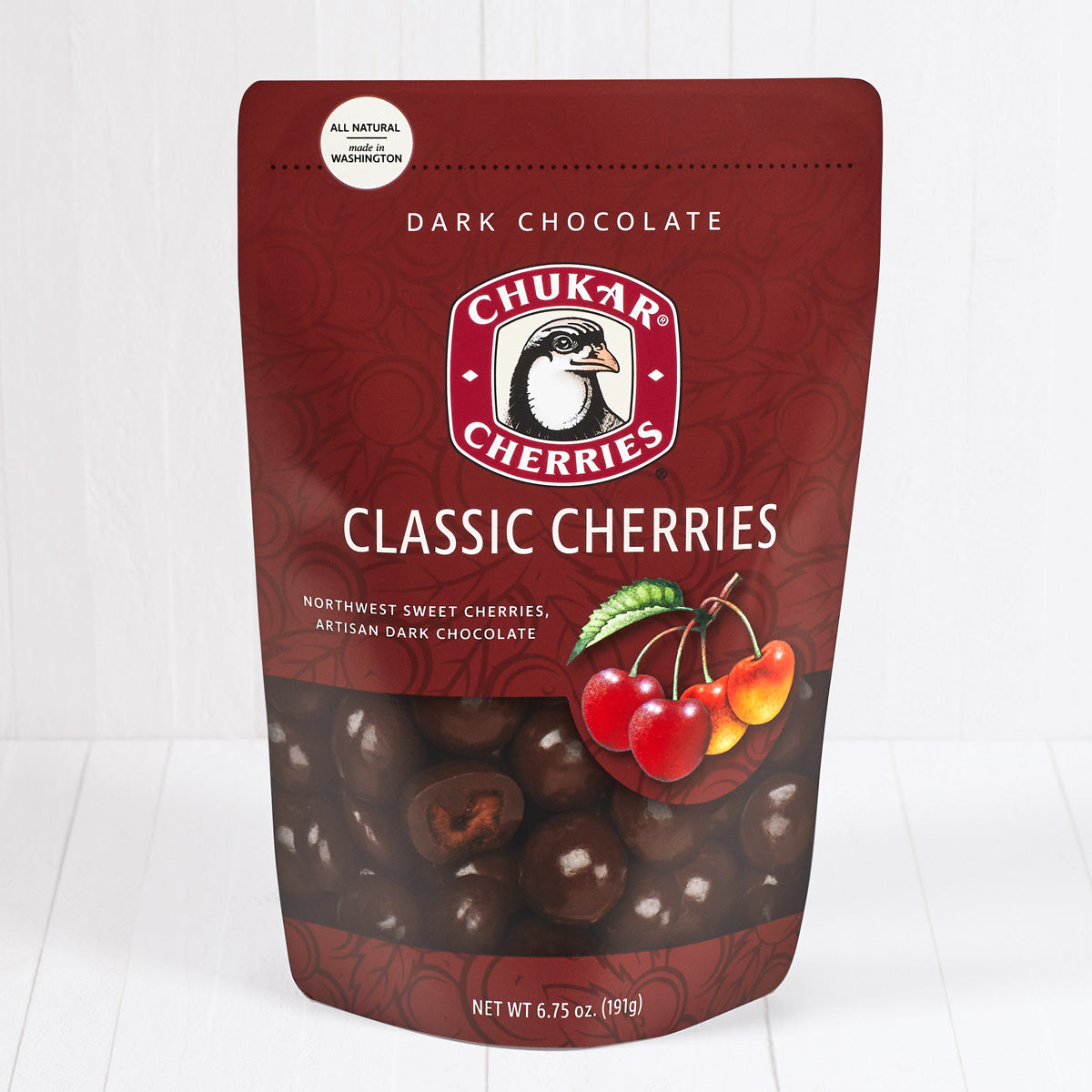 Whole and cut classic dark chocolate cherries shown in closed resealable bag