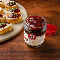 Plate of crostini topped with cheese and cherry pepper jelly. 
