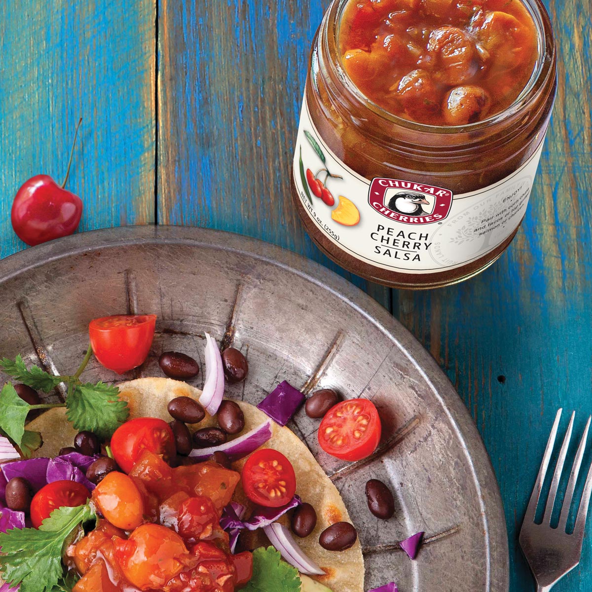 Open jar of peach cherry salsa next to black bean tostadas