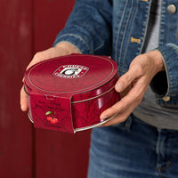 Red tin being hand delivered