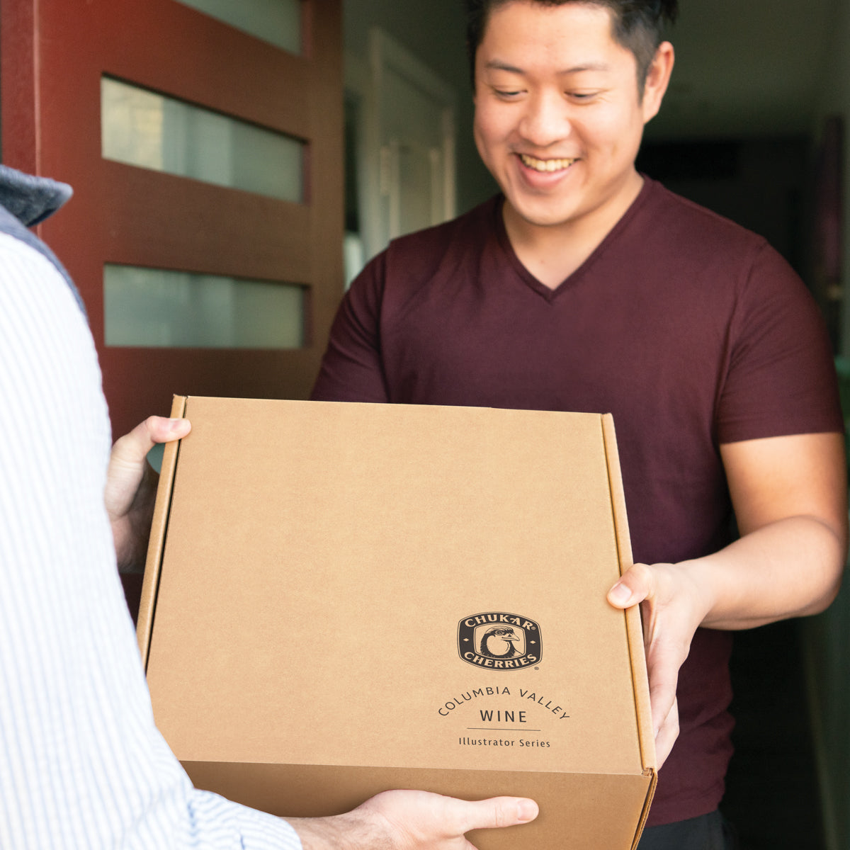 Man being given chukar cherries wine box and smiling