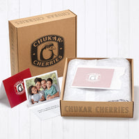 Three views of complimentary gift card shown; first view is of the front, second view is open with custom image and message, and the third view is in a vellum envelope placed at the top of the holiday joy bundle on the decorative inner wrapping. 